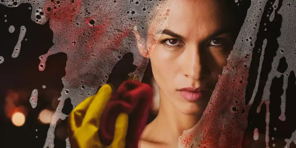 Femme nettoyant une vitre avec éponge rouge